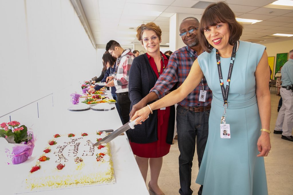 Photo of three people cutting the cake at this year's education celebration