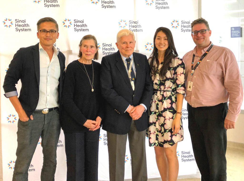 Group photo of Dr. David Yan (Ophthalmologist-in-Chief), Brenda Fowler, Dr. John Fowler, Dr. Stephanie Low (new Bridgepoint ophthalmologist), Dr. Mark Lachmann (Physician Lead) standing in front of Sinai Health System branded background